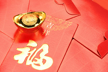 Kırmızı zarflar içinde paketlenmiş para hediyeleri ve yeni yıl için küçük altın barlar.